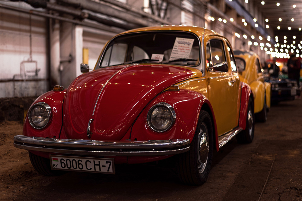 Orange classic Volkswagen Beetle on display at an indoor VW show
