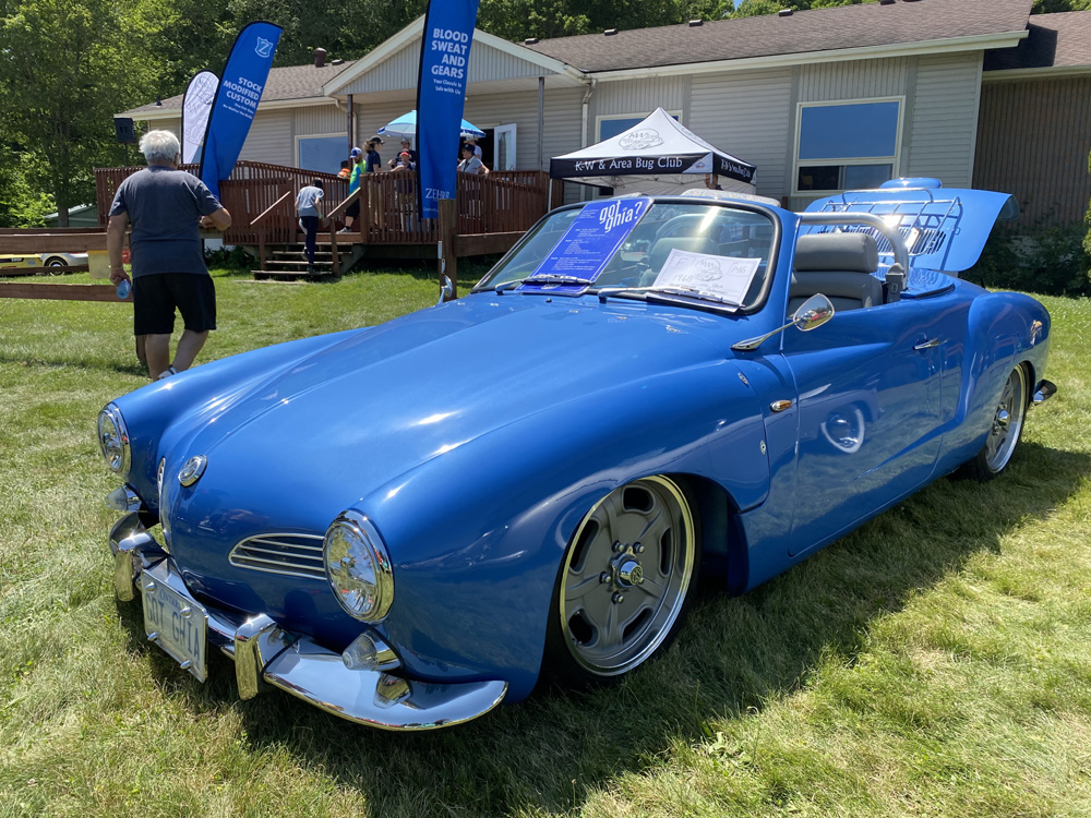 Bright blue Karmann Ghia convertible displayed at Bug Out 44 with custom wheels