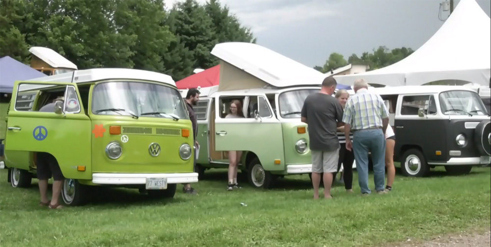 three VW buses in a row at the show