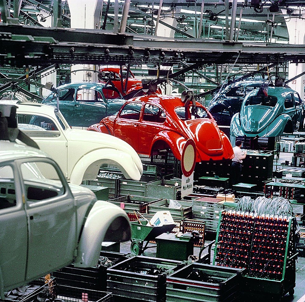 brightly painted 1967 model year bodies suspended from overhead conveyor chains