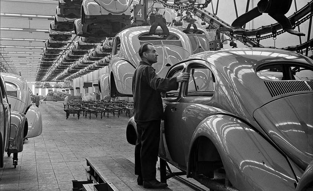 Newly painted Type 1 bodyshells moving slowly toward the fitting out and trim lines in the final assembly hall at Wolfsburg