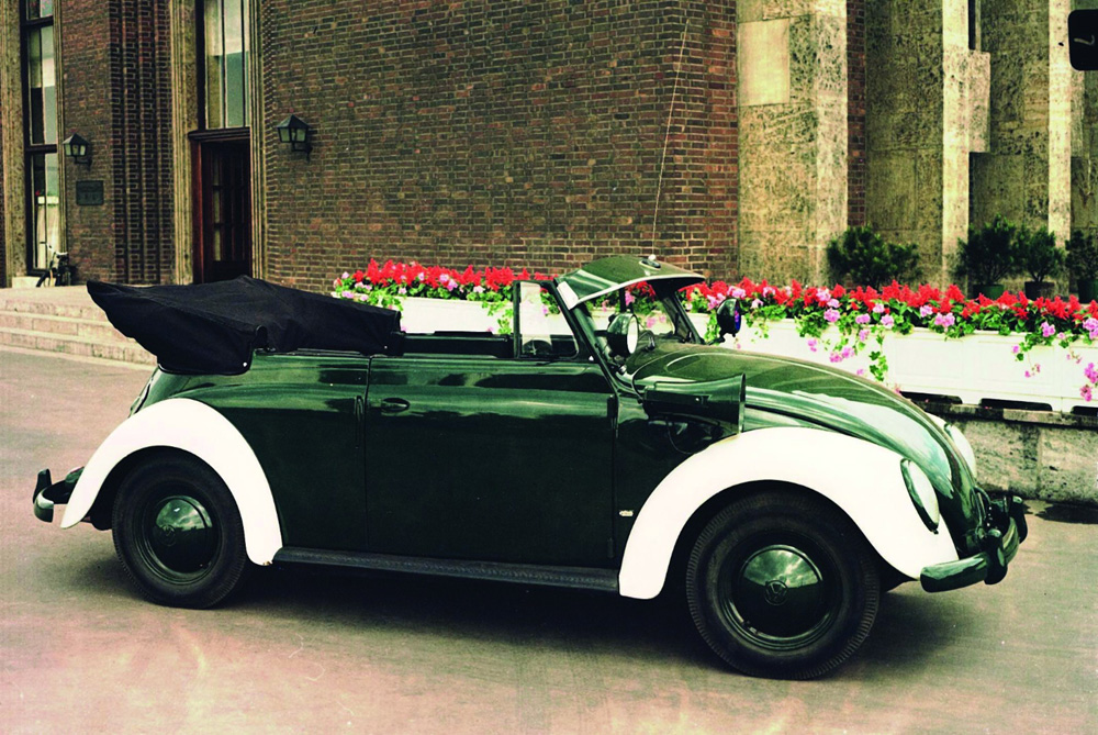 A new 1954 Karman Kabriolett fitted out as a police car parked outside the main entrance of the original three-storey Verwaltungsgeb&auml;ude administration building at the western end of the Volkswagen factory in Wolfsburg 