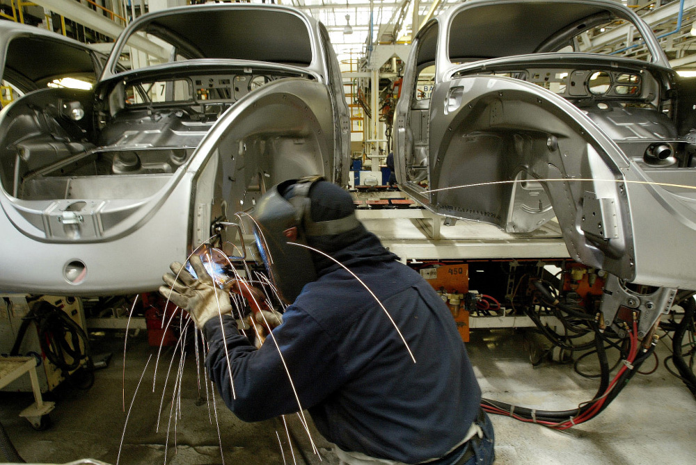 A VW factory worker is welding the front panel of a Vocho in Puebla, Mexico, around 2000-2003